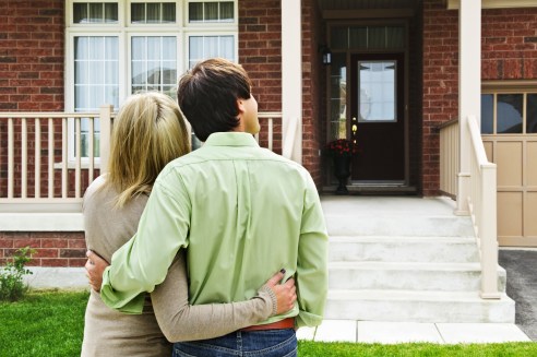 Young Couple Standing Outside House